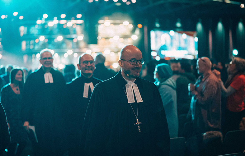 Landesbischof Tobias Bilz (Ev.-Luth. Landeskirche Sachsens, re.) feiert am 5.1.2026 gemeinsam mit Pfr. Swen Schönheit und Pfr. Thomas Bachmann den ev. Abendmahlsgottesdienst auf der MEHR-Konferenz in Augsburg. Foto: Johannes Molzahn